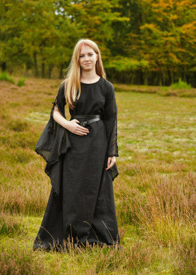 Robe médiévale Ingrid noire en coton portée en extérieur, coupe longue fluide, manches trompettes fendues visibles