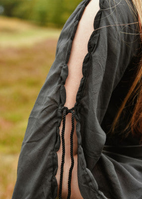 Robe médiévale Ingrid noire portée de face, coton respirant, tombé long structuré et manches fendues visibles
