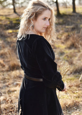 Vue trois quarts arrière de la robe cotehardie Isabell noire en velours portée avec ceinture en extérieur