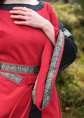 Détail du buste et de la manche trompette de la robe bliaut Joséphine rouge et noire, avec galon décoratif pour reconstitution