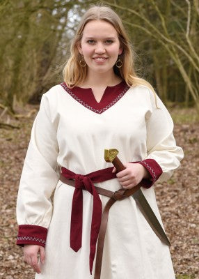 Robe viking Jona blanche en coton canvas, portée avec ceinture rouge, épée visible et encolure brodée pour reconstitution, GN ou LARP