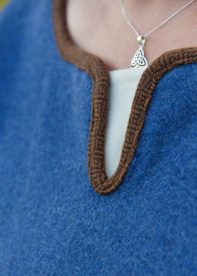 Détail de l’encolure fendue de la robe viking Lykka bleue avec bordure brun losangé