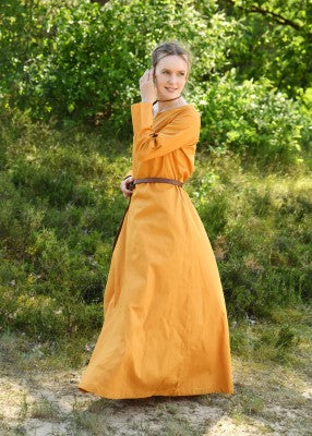 Robe médiévale Milla orange – vue de profil portée, robe longue ample en coton, encolure fendue, mouvement de jupe extérieur