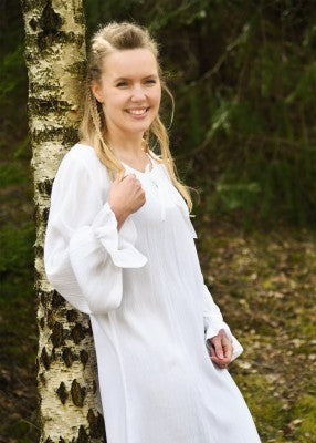 Sous-robe légère blanche en tissu fluide effet froissé, avec manches longues et encolure ajustable par ruban satiné