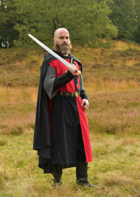 Tabard rouge et noir au lion porté avec cape, cotte de mailles et épée pour personnage de chevalier en reconstitution, GN et LARP