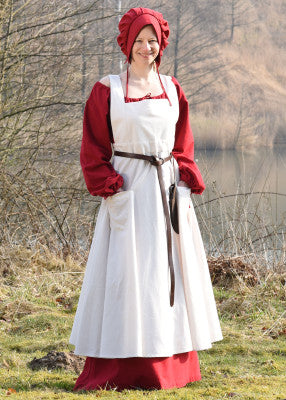 Tablier Ruth médiéval - coloris naturel, coton naturel, vue de face au lac, porté sur robe rouge, reconstitution GN LARP