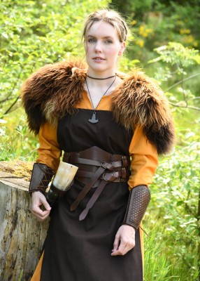Détail du tablier viking Tinna brun porté sur robe ocre, avec buste droit et ceinture en cuir