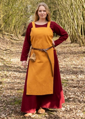 Tablier viking Tinna jaune porté sur une robe rouge, avec coupe ouverte et laçage latéral pour reconstitution, GN ou LARP