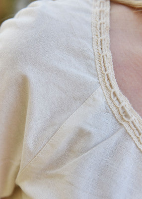 Détail de la tunique Aren naturelle, avec dentelle à l’encolure et manche courte froncée