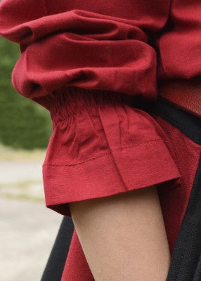 Tunique Helena pour enfant en coton rouge, détail du poignet élastiqué et de la manche pour reconstitution, GN ou LARP enfant